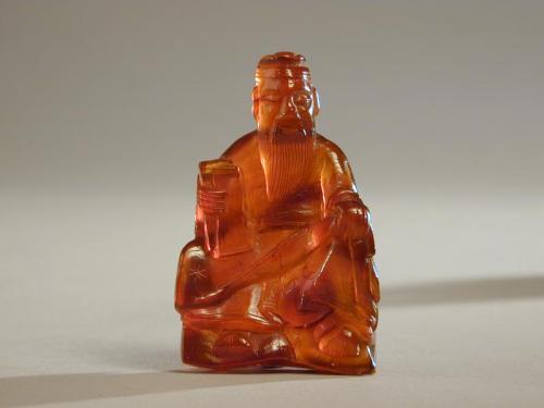 Small Amber Carving of a Seated Immortal