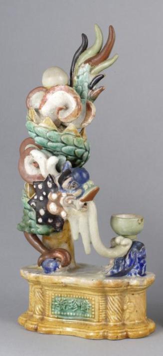 One of a Pair of Shiwan Ware Candleholders with Coiled Dragon