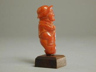 Amber Whistle Carved in the form of a Man on a Rock